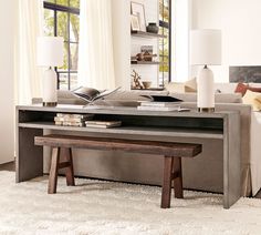 a living room with a couch, coffee table and bookshelf in the corner