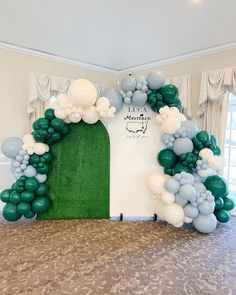 an arch made out of balloons in the middle of a room with a green door