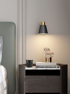 a nightstand with a lamp on top of it next to a bed