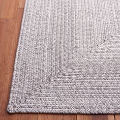 a gray rug on top of a wooden floor