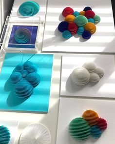 several different colored paper sculptures on display in a room