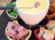 there is a bowl of soup with meat in it and other foods on the table