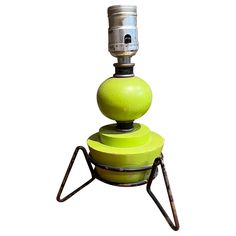 a green lamp sitting on top of a metal stand