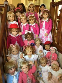 a bunch of dolls that are sitting on the stairs