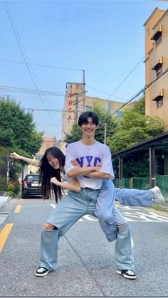 two people standing in the middle of an empty street with one person on his back