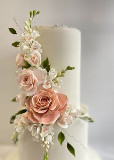 a wedding cake decorated with flowers and greenery