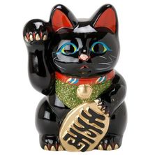 a black cat figurine holding a gold coin