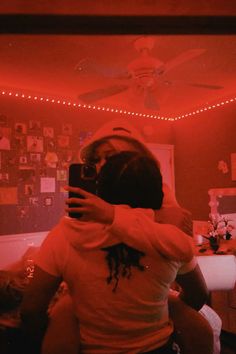 a woman taking a selfie in front of a mirror with red lights on the ceiling