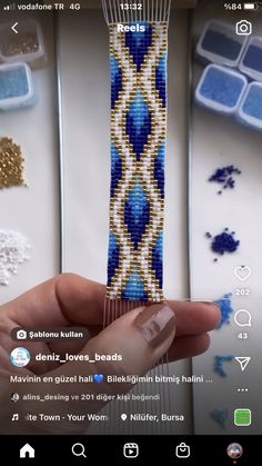 someone is holding up a beaded bracelet in their hand and it looks like they are making something out of beads