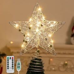 a star shaped christmas tree topper with remotes next to it on a table