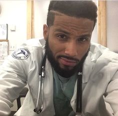 a man with a stethoscope on his neck sitting in front of a desk