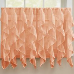 an orange ruffled curtain hangs in front of a window