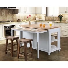 a kitchen island with two stools next to it and an oven in the background