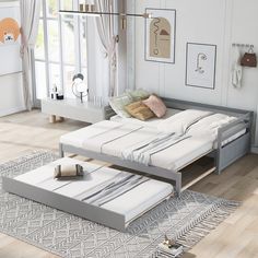 a bed sitting on top of a wooden floor next to a window