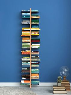 a bookshelf made out of many books in a room with blue walls and white carpet