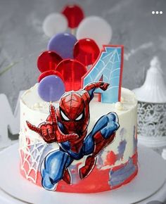 a spiderman birthday cake with balloons on top