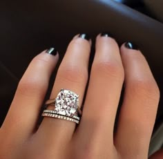 a woman's hand with two rings and a diamond ring on her left hand