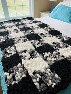 a large crocheted blanket on top of a bed