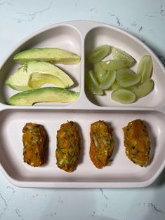 a white tray with four compartments filled with different types of food on top of it