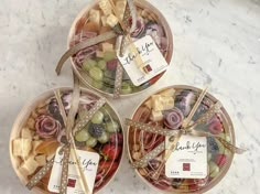 three baskets filled with different types of fruit on top of a marble countertop next to each other