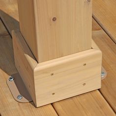 a wooden stand with two pieces of wood attached to it on top of a wooden floor