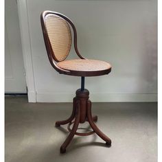 an antique wooden chair with wicker seat and footrests, on casteors