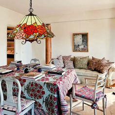 a dining room table with chairs and a chandelier hanging from it's ceiling