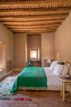 a bedroom with a large bed and wooden ceiling