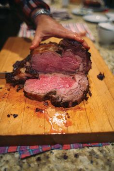 a person is slicing up some meat on a cutting board