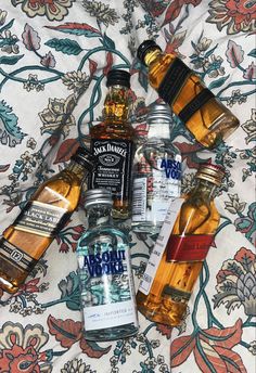 several bottles of liquor sitting on top of a bed