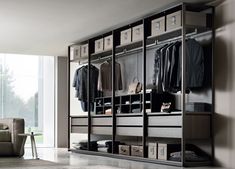 a large open closet with clothes hanging on it