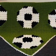 a crocheted blanket with soccer balls on it