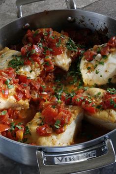 fish with tomatoes and parsley in a pan