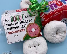 two donuts and a candy wrapper on a blue surface with a sign that says, we donut know what we would do without you happy christmas from