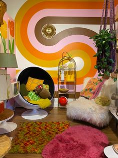 a living room filled with lots of furniture and colorful wall paper on the walls behind it