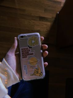 someone holding up their phone case with stickers on it