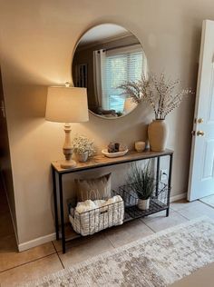 a living room with a mirror, vases and other items on the table in front of it