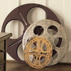 an old movie projector sitting on top of a wooden table next to a dresser