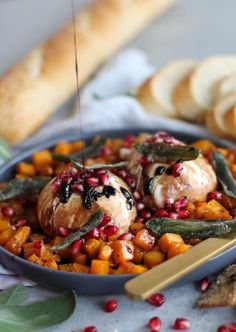 some food is sitting in a bowl on a table with bread and other items around it