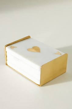 a stack of white and gold napkins with heart cutouts on the front cover