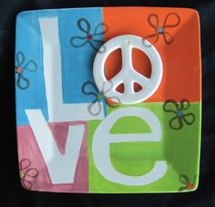 a peace sign on a colorful plate that says love