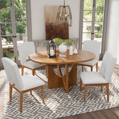 a dining room table with white chairs and an area rug in front of the window