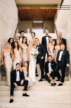 a group of people in formal wear posing on stairs