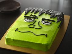 a cake that looks like the face of a monster on top of a cutting board