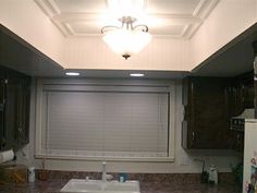 a kitchen with dark wood cabinets and marble counter tops, along with a white ceiling fan