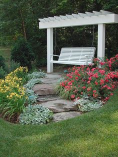 a white bench sitting in the middle of a garden