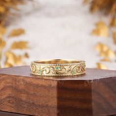 a close up of a gold ring on a wooden surface