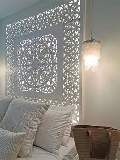 a bed with white sheets and pillows next to a basket on top of the bed