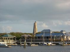 boats are docked in the water next to buildings and a light house with a blue roof