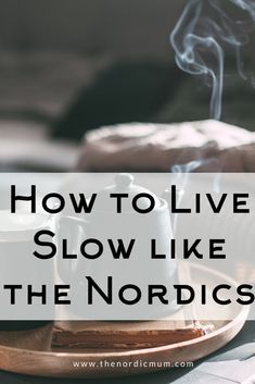 the words how to live slow like the nordics on top of a wooden plate